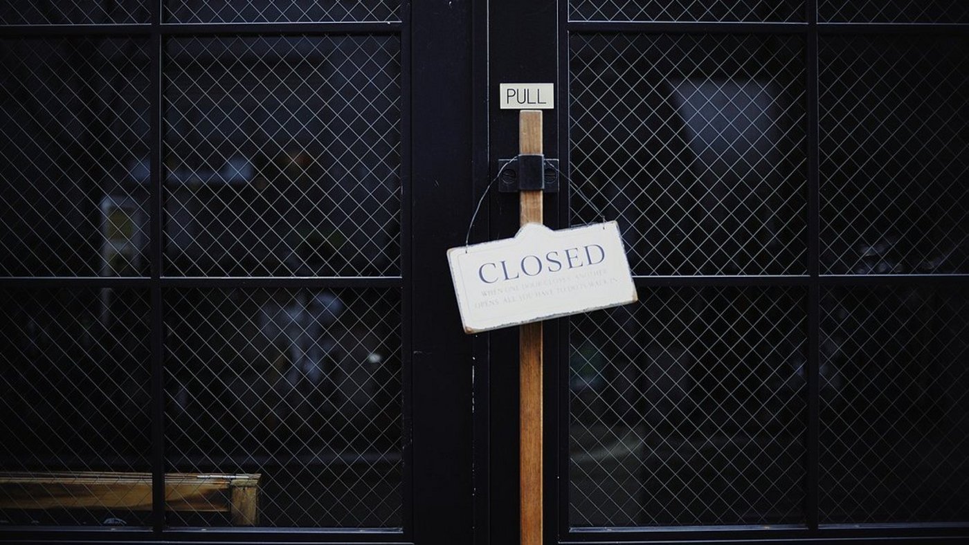 Vergitterte, verriegelte Tür und Schild "closed"